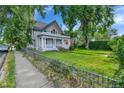 Two-story home with welcoming front porch and yard, complemented by a wrought-iron fence at 7011 Grandview Ave, Arvada, CO 80002