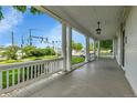 A covered porch with white pillars, offering an outdoor seating area with a view of the street at 7011 Grandview Ave, Arvada, CO 80002