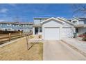 Charming two-story home featuring light blue siding and attached garage and manicured lawn at 11141 Gaylord St, Northglenn, CO 80233