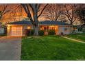Charming single-story home with lush green lawn, walkway and driveway with detached garage at 1935 Oneida St, Denver, CO 80220