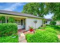 Close-up of the home's entrance and charming front yard, complete with garden and vibrant flowers at 1935 Oneida St, Denver, CO 80220