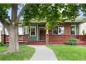 Inviting front porch with brick and wood accents, leading to a well-manicured lawn at 1544 S Elizabeth St, Denver, CO 80210