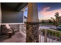 Cozy front porch with stone pillar, decorative railing, and a peaceful view of the neighborhood at 11560 Kalispell St, Commerce City, CO 80022