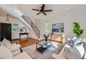 Bright living room with hardwood floors, stylish decor, a modern ceiling fan, and ample natural light at 3802 Chaffee Ct, Castle Rock, CO 80109