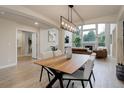 Open concept dining room leading to the living room with many windows and light wood floors at 14075 Turnberry Ct, Broomfield, CO 80023