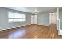 Bright living room with hardwood floors, large window, and neutral paint colors at 7704 Newland St, Arvada, CO 80003