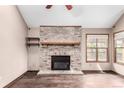Living room featuring a brick fireplace with hearth, wood flooring and a window with a view to the backyard at 5421 S Vivian St, Littleton, CO 80127
