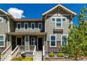 Charming townhome showcasing a covered porch, complemented by verdant landscaping and detailed architectural trim at 17706 Cherokee St, Broomfield, CO 80023