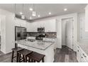 Modern kitchen with white cabinets, stainless steel appliances, and a center island with barstool seating at 17706 Cherokee St, Broomfield, CO 80023
