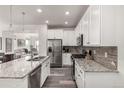 Modern kitchen with stainless steel appliances, granite countertops, and ample cabinet space at 17706 Cherokee St, Broomfield, CO 80023