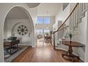 Inviting foyer with hardwood floors, staircase, arched doorways, and decorative wall art at 22485 Laurel Oak Dr, Parker, CO 80138