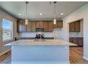 Modern kitchen with granite counters, stainless appliances, wooden cabinets, and a center island at 16858 Greyhawk Dr, Monument, CO 80132