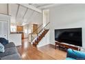 Open-concept living area featuring hardwood floors, a staircase, and views into the kitchen at 961 S Miller Way, Lakewood, CO 80226