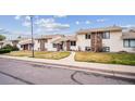 A view of the townhouses on a tree-lined street, each with unique front lawns that provides curb appeal at 961 S Miller Way, Lakewood, CO 80226