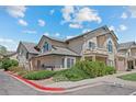 Exterior of multi-Gathering home features manicured landscaping, a private balcony, and clearly marked reserved parking at 8603 E Dry Creek Rd # 214, Englewood, CO 80112