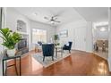 Bright living room boasts a fireplace, wood floors, ceiling fan, two chairs, and an open floor plan at 8603 E Dry Creek Rd # 214, Englewood, CO 80112