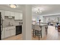 Modern kitchen with white cabinets, stainless appliances, and breakfast bar at 800 N Washington St # 307, Denver, CO 80203