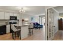 Bright living room featuring light wood floors, kitchen, and sliding door to deck at 800 N Washington St # 307, Denver, CO 80203