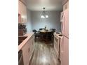 Eat-in kitchen featuring white cabinetry, modern appliances, and an adjacent dining area with seating at 561 E Geneva N St # 103, Aurora, CO 80010