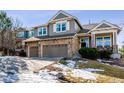 Two-story house with stone accents, two-car garage, and a landscaped yard at 1575 Ridgetrail Ct, Castle Rock, CO 80104