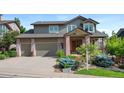 Attractive two-story home featuring a brick-accented facade, attached two-car garage, and professionally landscaped front yard at 9 Amaranth Dr, Littleton, CO 80127