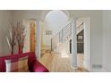Grand foyer showcasing hardwood floors, decorative columns, and an open staircase with modern railings at 9 Amaranth Dr, Littleton, CO 80127