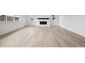 Open-concept living room with fireplace, wood flooring, and lots of natural light at 24768 E 40Th Ave, Aurora, CO 80019
