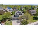 Aerial view of a home surrounded by lush greenery, trees, and neighborhood rooftops at 4875 E 117Th Dr, Thornton, CO 80233