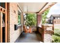 Cozy covered porch with a swing, brick pillars, and views of the neighborhood at 315 S Franklin St, Denver, CO 80209