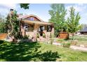 Brick home with covered porch, mature trees, and a well-manicured lawn create a warm and inviting atmosphere at 315 S Franklin St, Denver, CO 80209
