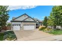 Beautiful home showcasing meticulous landscaping and a spacious driveway leading to a three-car garage at 21064 Woodside Ln, Parker, CO 80138