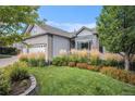 Eye-catching front yard with vibrant flower beds, healthy lawn, and an American flag at 21064 Woodside Ln, Parker, CO 80138