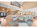 Open-concept living room featuring hardwood floors, a grand staircase, and ample seating at 7035 S Picadilly St, Aurora, CO 80016