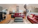 Cozy living room with a red leather sofa, hardwood floors, and views of the unique spiral staircase at 1165 N Pennsylvania St # 3B, Denver, CO 80203