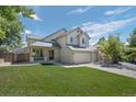 Two-story house with attached garage and manicured lawn at 6858 Johnson St, Arvada, CO 80004