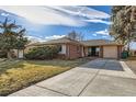 Well-maintained brick home with a spacious driveway and manicured lawn, perfect for suburban living at 2675 N Saint Paul St, Denver, CO 80205