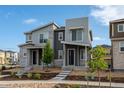 Modern home with stone accents, complemented by a landscaped front yard and a clear blue sky at 5319 Warrior St, Frederick, CO 80504