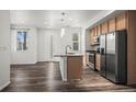 Bright, open kitchen with a central island, stainless steel appliances, and stylish pendant lighting at 5319 Warrior St, Frederick, CO 80504