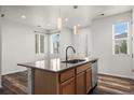 Contemporary kitchen featuring an island with seating, stainless steel appliances, and ample natural light at 5319 Warrior St, Frederick, CO 80504