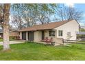 Charming single-story home with a well-manicured lawn, brick accents, and cozy front porch at 1000 Zang St, Golden, CO 80401