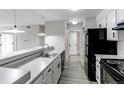 Modern kitchen features black appliances, white cabinets, sleek countertops, and stainless steel sink at 4899 S Dudley St # 15B, Littleton, CO 80123