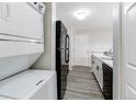 Well-organized kitchen near stacked washer/dryer with black appliances, and white cabinets at 4899 S Dudley St # 15B, Littleton, CO 80123