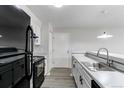 Modern kitchen has black appliances, white cabinets, sleek countertops, and updated lighting at 4899 S Dudley St # 15B, Littleton, CO 80123