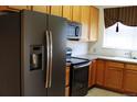 Well-lit kitchen features stainless steel appliances and natural wood cabinets and countertops at 3220 Boulder Cir # 103, Broomfield, CO 80023