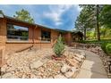 Inviting front yard with a stone walkway, rock garden, and lush landscaping, creating a warm and welcoming curb appeal at 19 Rock Ln, Castle Rock, CO 80104