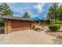 Spacious two-car garage with beautiful brick accents and a large driveway, providing ample parking space at 19 Rock Ln, Castle Rock, CO 80104