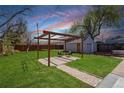 Spacious backyard featuring a pergola-covered patio, ideal for outdoor entertaining and relaxation at 5612 Ammons St, Arvada, CO 80002