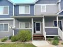 Inviting townhome featuring a charming front porch, landscaped yard, and two-tone gray and blue color scheme at 19246 E Idaho Pl # 102, Aurora, CO 80017