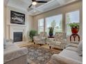 Bright living room with a fireplace, coffered ceilings, and large windows, offering ample natural light at 23636 E Del Norte Pl, Aurora, CO 80016