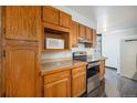 This cozy kitchen includes wooden cabinets, a smooth cooktop, and updated backsplash at 1625 Larimer St # 605, Denver, CO 80202